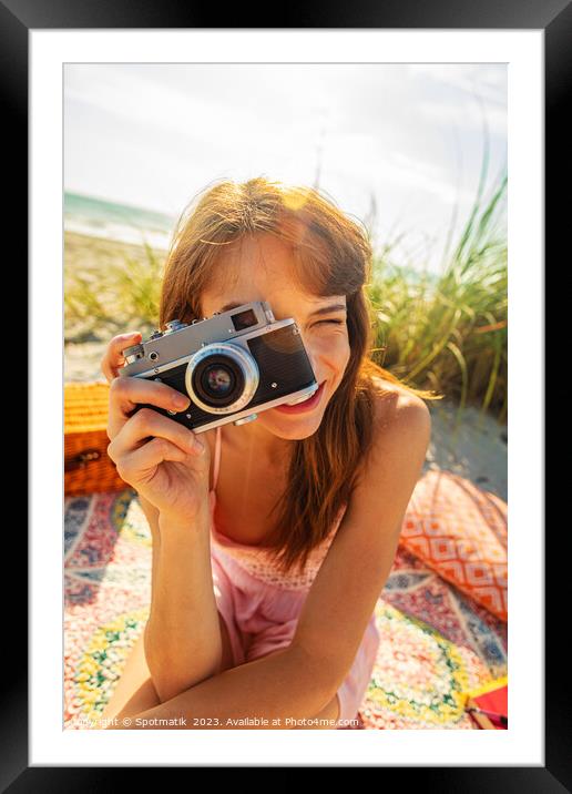 Smiling Caucasian girl with camera photographing beach vacation Framed Mounted Print by Spotmatik 