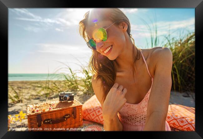 Smiling Caucasian girl relaxing on blanket at beach Framed Print by Spotmatik 