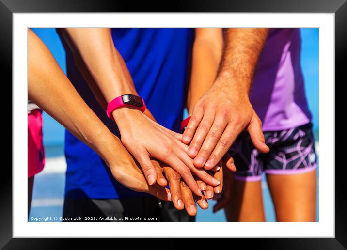 Multi ethnic friends joining hands after beach workout Framed Mounted Print by Spotmatik 