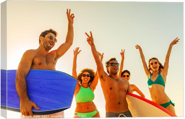 Friends enjoying carefree fun going bodyboarding on beach Canvas Print by Spotmatik 