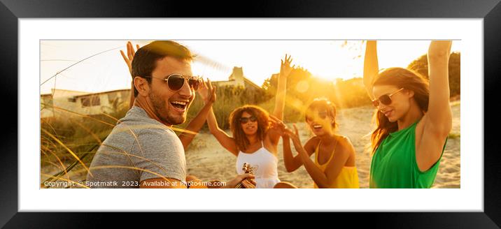 Friends relaxing at sunset on beach playing guitar Framed Mounted Print by Spotmatik 