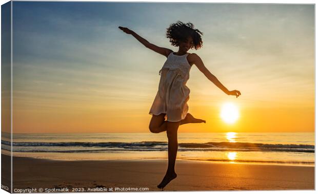 Barefoot young African American woman dancing on beach Canvas Print by Spotmatik 