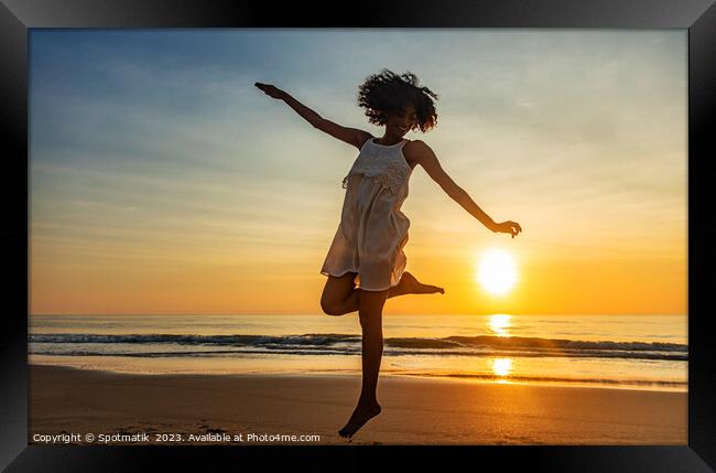 Barefoot young African American woman dancing on beach Framed Print by Spotmatik 