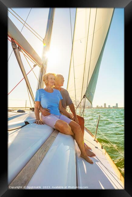 Senior couple enjoying togetherness on yacht at sunset Framed Print by Spotmatik 