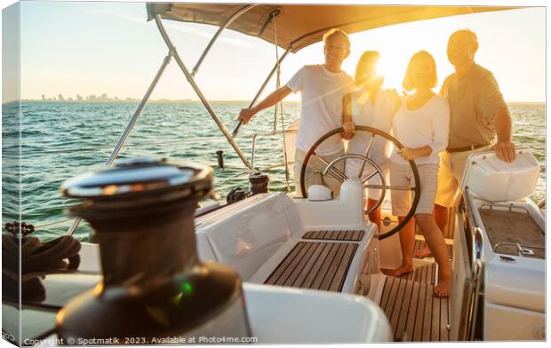 Senior friends enjoying retirement steering yacht at sunset Canvas Print by Spotmatik 