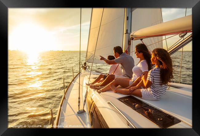 Relaxed family on luxury yacht sailing towards sunset Framed Print by Spotmatik 