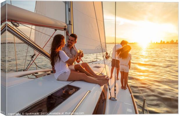 Young family having fun on yacht at sunset Canvas Print by Spotmatik 