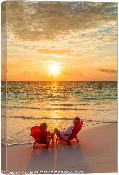 Sunset view with retired couple relaxing by ocean Canvas Print by Spotmatik 