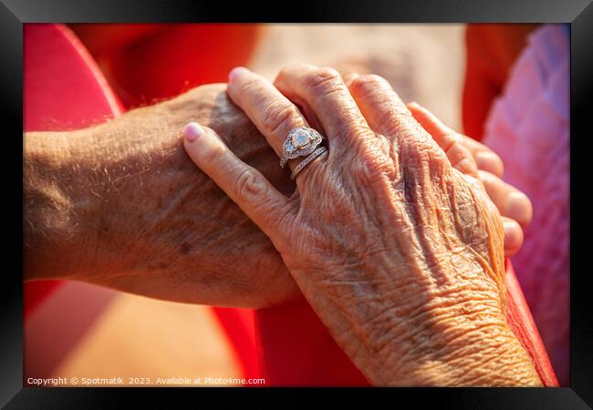 Linked hands of senior Caucasian couple on vacation Framed Print by Spotmatik 