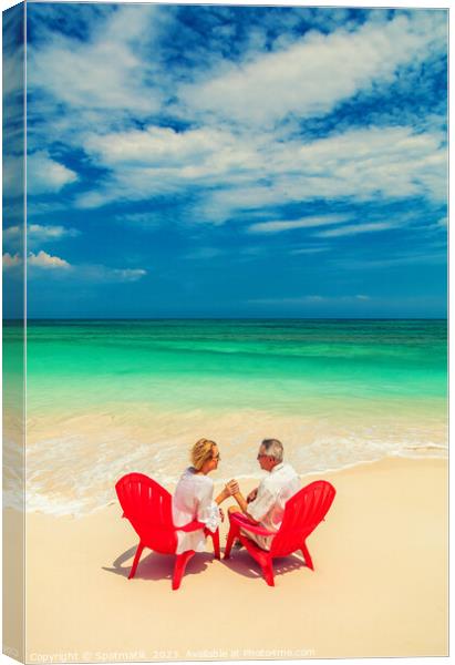 Mature couple on red chairs by ocean Bahamas Canvas Print by Spotmatik 