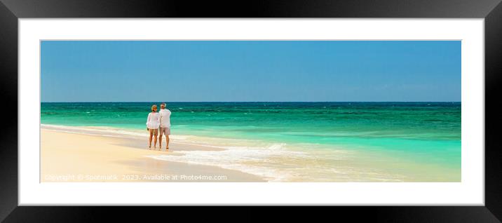 Panoramic view of mature couple walking on beach Framed Mounted Print by Spotmatik 