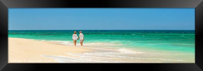 Panoramic retired couple by ocean at island resort Framed Print by Spotmatik 