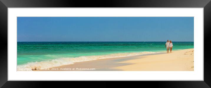 Panoramic view mature couple walking on deserted beach Framed Mounted Print by Spotmatik 