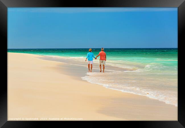 Mature couple paddling on tropical island shoreline Bahamas Framed Print by Spotmatik 