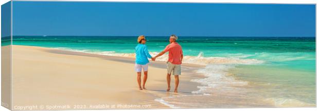 Panoramic beach view with retired couple holding hands Canvas Print by Spotmatik 