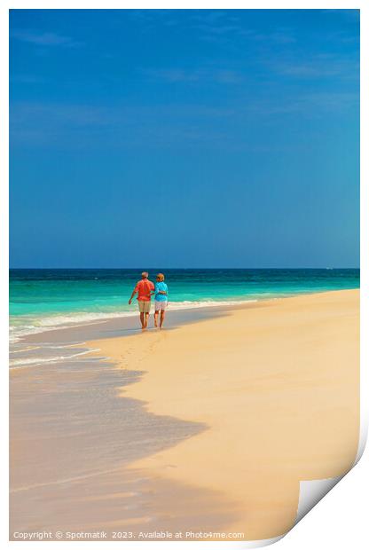 Tropical island shoreline with retired couple walking barefoot Print by Spotmatik 