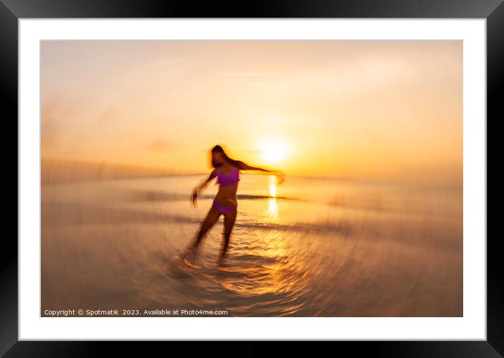 Motion blurred Asian girl dancing in ocean sunset Framed Mounted Print by Spotmatik 