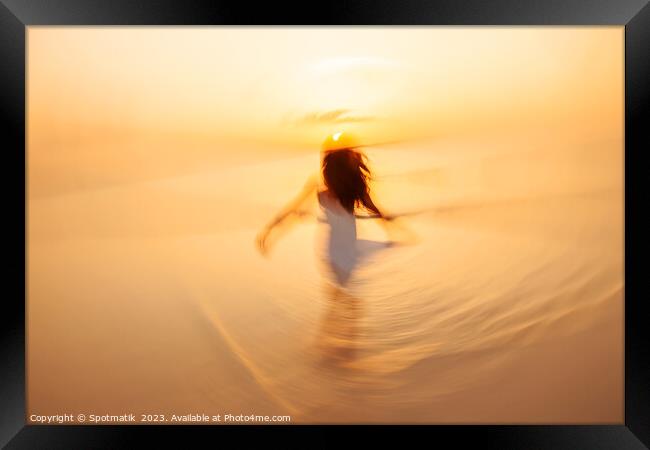 Motion blurred Asian girl dancing in ocean sunrise Framed Print by Spotmatik 