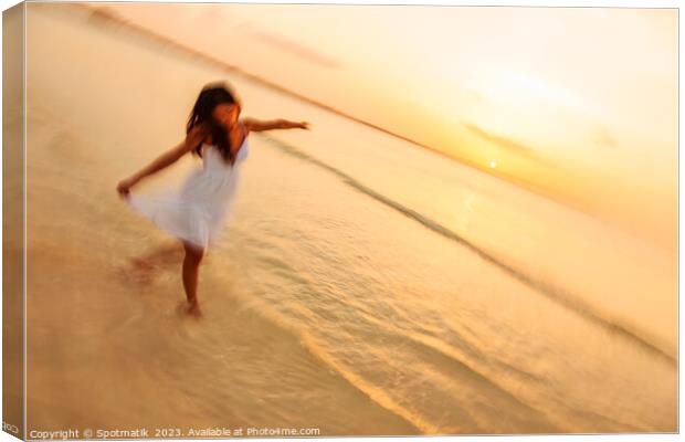 Motion blur carefree Asian female dancing on shoreline Canvas Print by Spotmatik 