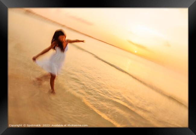 Motion blur carefree Asian female dancing on shoreline Framed Print by Spotmatik 