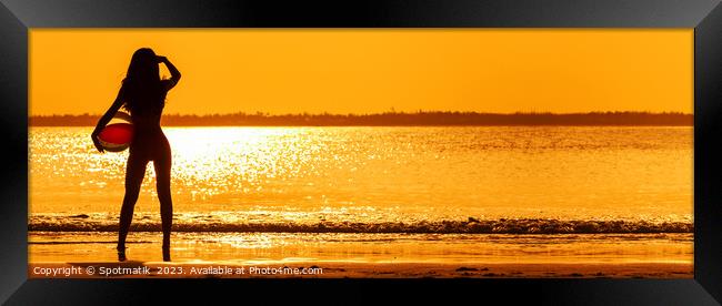 Panoramic Asian girl watching sunset over shimmering ocean Framed Print by Spotmatik 