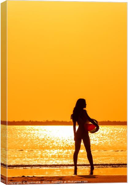 Tropical ocean sunrise with girl holding beach ball Canvas Print by Spotmatik 
