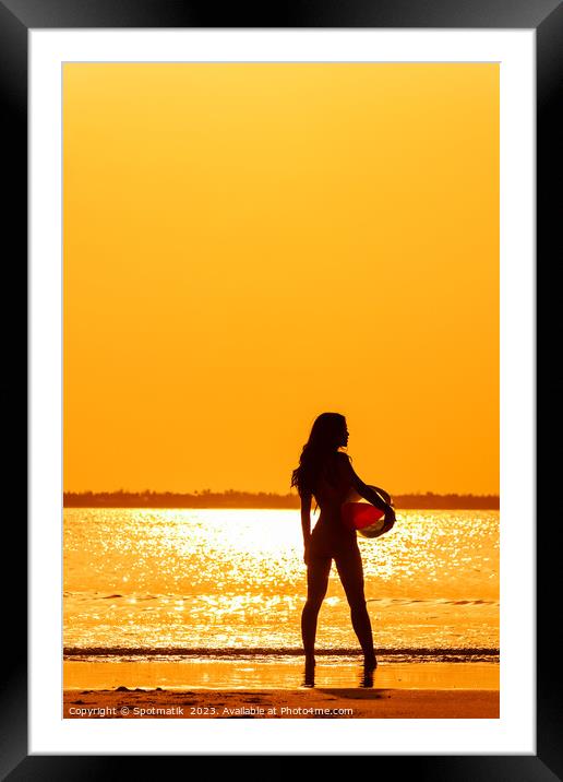 Tropical ocean sunrise with girl holding beach ball Framed Mounted Print by Spotmatik 