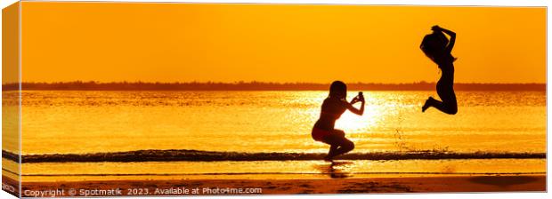 Panoramic ocean sunrise with girl jumping for photo Canvas Print by Spotmatik 