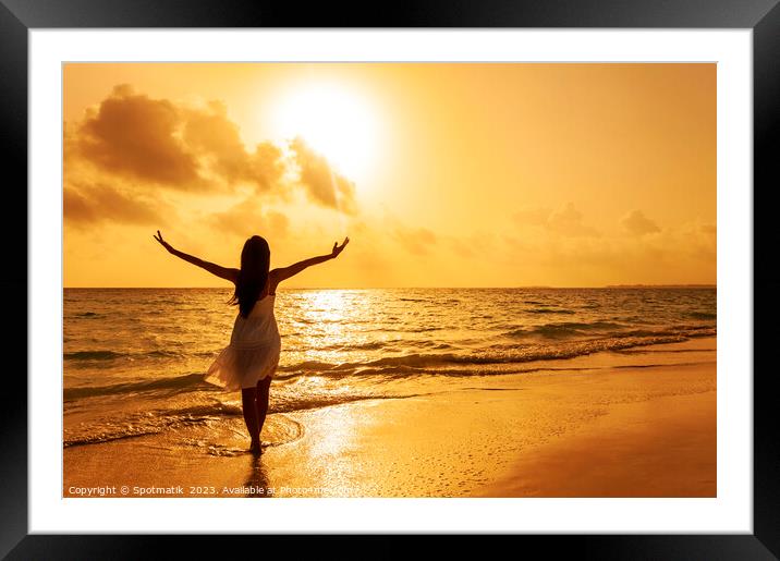 Asian female dancing in ocean waves at sunrise Framed Mounted Print by Spotmatik 