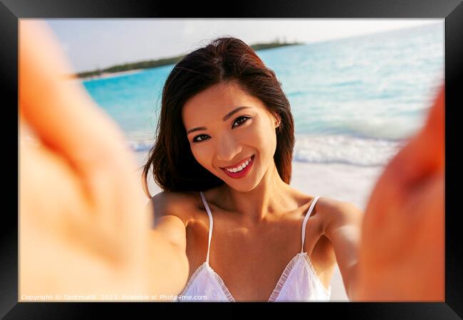 Portrait of beautiful Asian girl smiling by ocean Framed Print by Spotmatik 