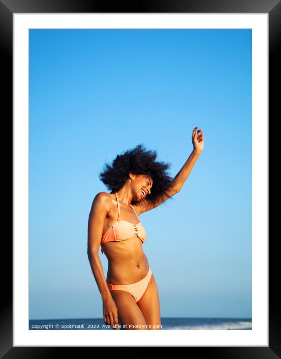 Afro girl in swimwear dancing on the beach Framed Mounted Print by Spotmatik 