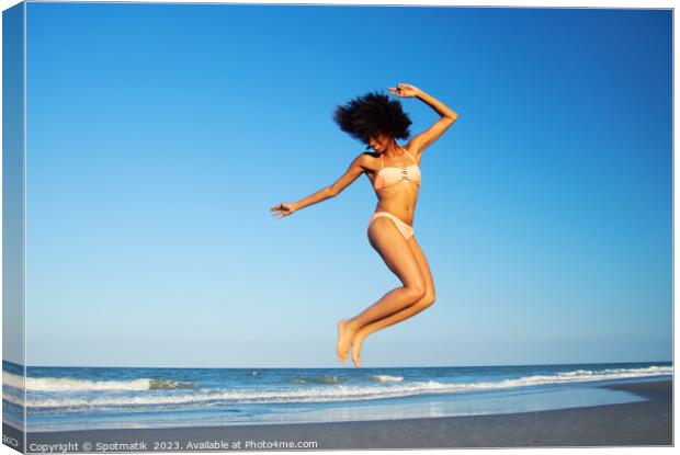 Afro American woman jumping for joy on beach Canvas Print by Spotmatik 