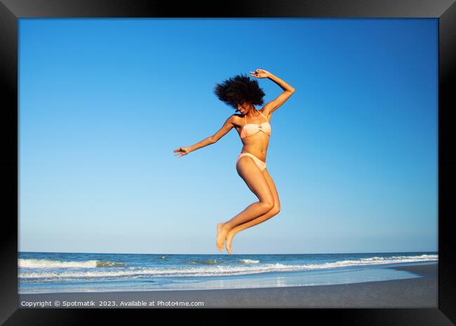 Afro American woman jumping for joy on beach Framed Print by Spotmatik 