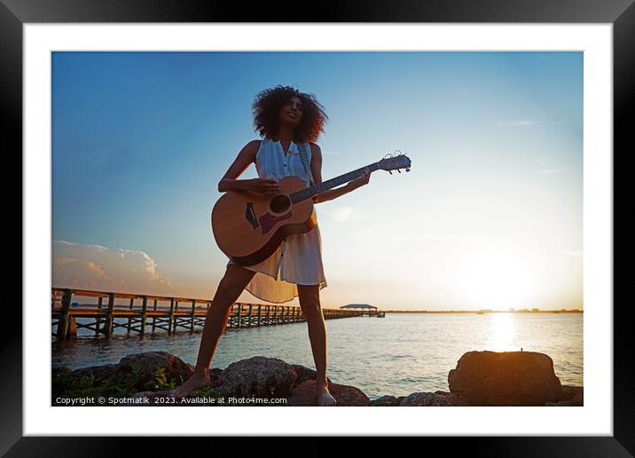 Young African American woman playing guitar at sunrise Framed Mounted Print by Spotmatik 