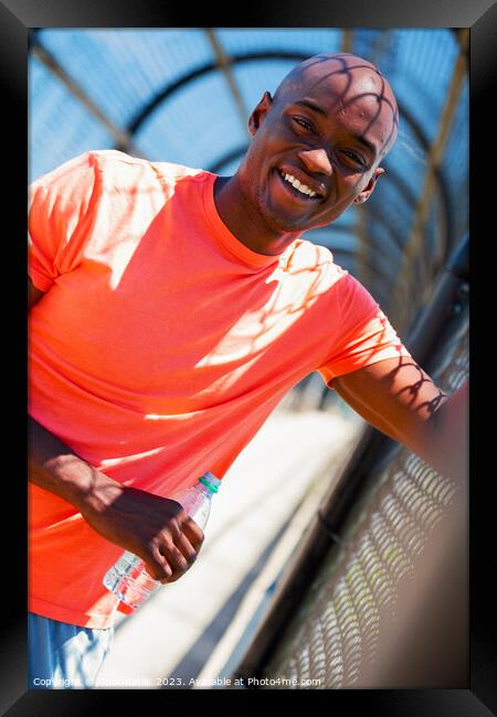 Portrait of African American male with water bottle Framed Print by Spotmatik 