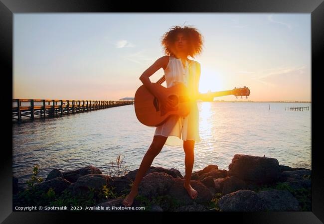 Afro American girl playing guitar with ocean sunset Framed Print by Spotmatik 