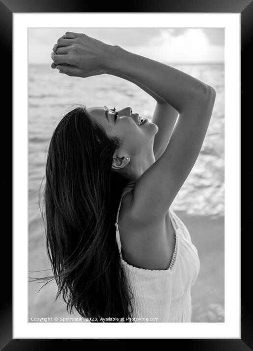 Asian female smiling with arms outstretched by ocean Framed Mounted Print by Spotmatik 