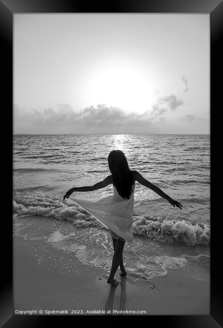 Asian girl with arms outstretched by the ocean Framed Print by Spotmatik 