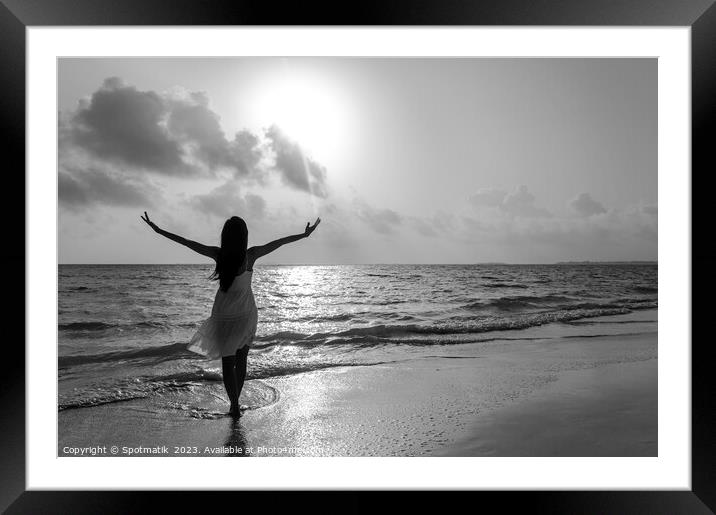 Asian woman by the ocean with outstretched arms Framed Mounted Print by Spotmatik 