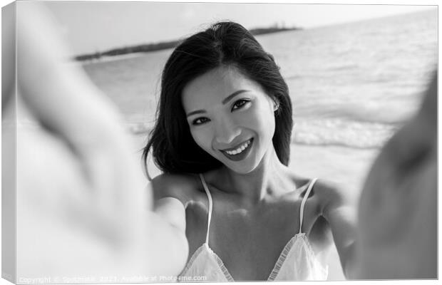 Outdoor portrait of smiling Asian female reaching out Canvas Print by Spotmatik 