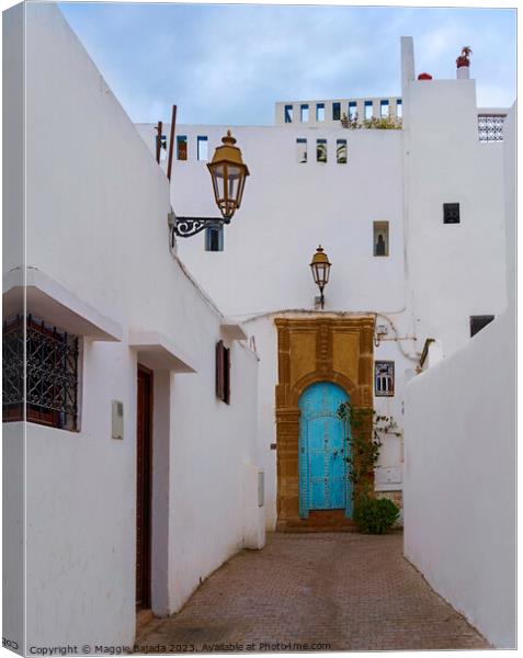 White Building with Blue Door in Rabat, Morocco. Canvas Print by Maggie Bajada