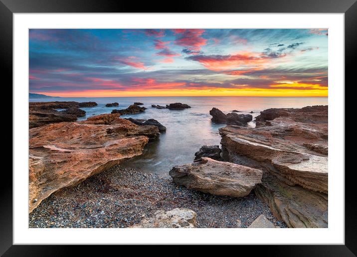 Stunning sunrise over the beach and rocks at Torre de la Sal  Framed Mounted Print by Helen Hotson