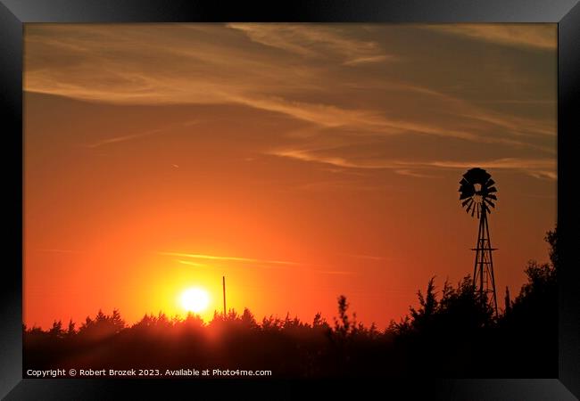 Sunset with an orange sky and Windmill silhouette Framed Print by Robert Brozek