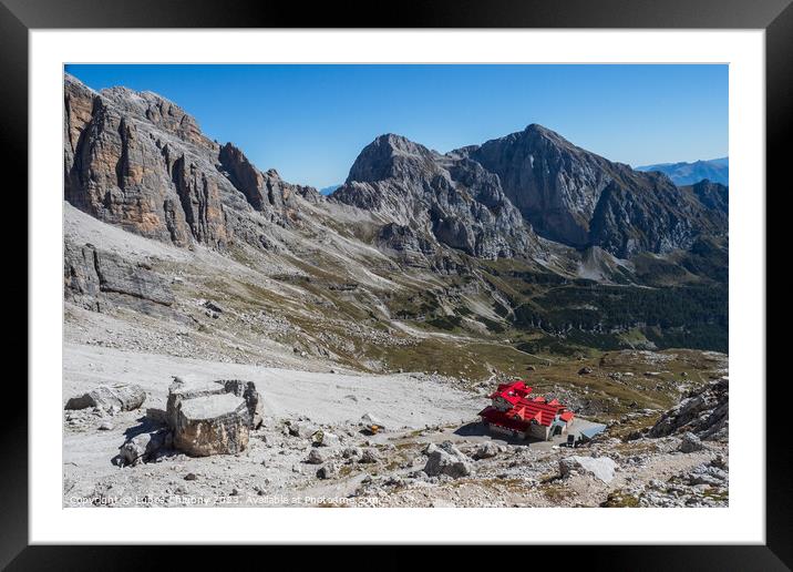 Tourist with hiking backpacks in mountain hike on summer day. Man traveler hiking in beautiful mountain landscape. Climber and alpine hut Silvio Agostini in Dolomites Alps, Italy. Framed Mounted Print by Lubos Chlubny