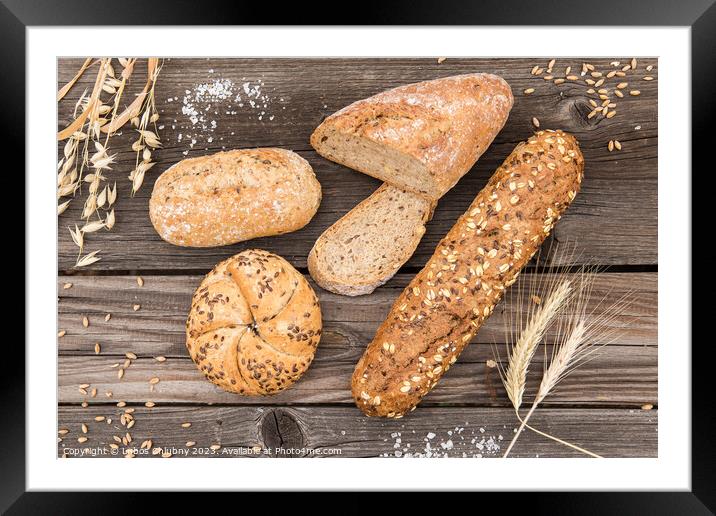 Background of fresh bread and bakery on an old vintage planked wood table. Framed Mounted Print by Lubos Chlubny