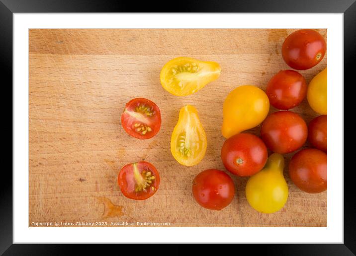 Red and yellow cherry tomatoes on a wooden cutting board Framed Mounted Print by Lubos Chlubny
