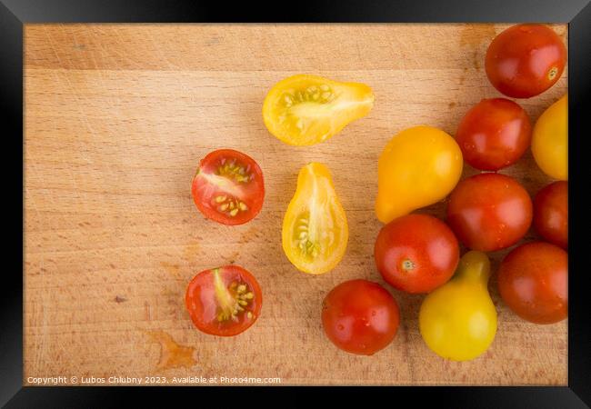 Red and yellow cherry tomatoes on a wooden cutting board Framed Print by Lubos Chlubny