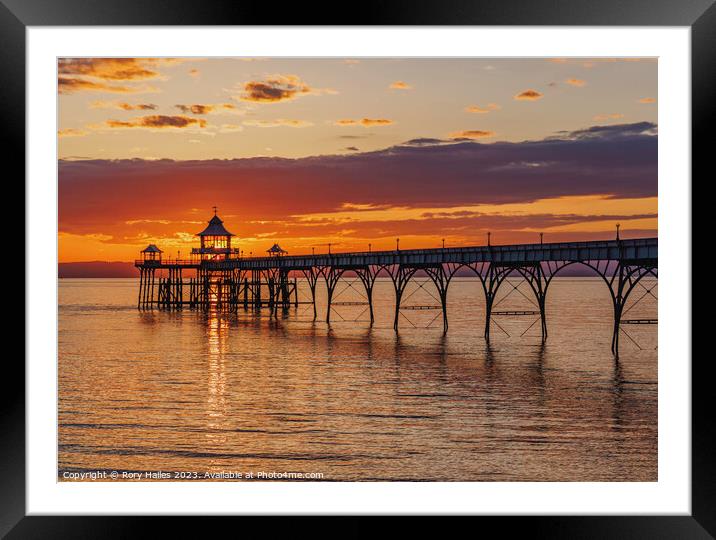 Clevedon Pier at sunset with a streak of sunlight going through the pier head Framed Mounted Print by Rory Hailes