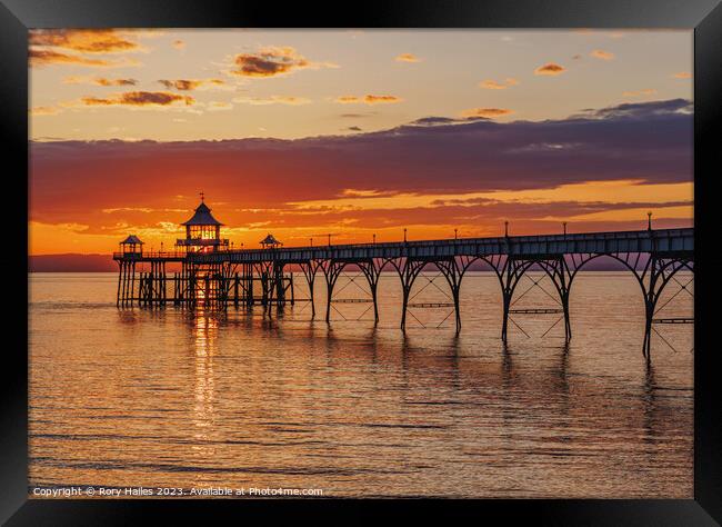 Clevedon Pier at sunset with a streak of sunlight going through the pier head Framed Print by Rory Hailes