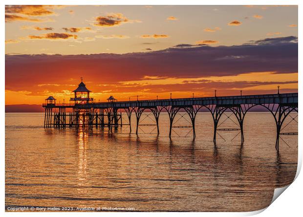 Clevedon Pier at sunset with a streak of sunlight going through the pier head Print by Rory Hailes